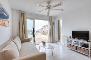 a living room with a couch and a flat screen tv at La Rose des Sables Arcachon in Arcachon