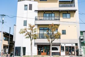 dos árboles frente a un edificio en Guest House Ouka en Takayama