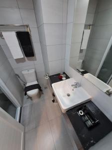 a small bathroom with a sink and a toilet at Zia Sanno Menteng Residences- Jakarta in Jakarta