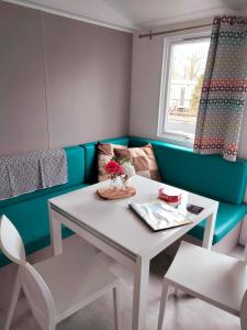 ラウエルウオーフにあるBJ Chalets - Robbengat 85 - Gezellige, kindvriendelijke chalet op vakantiepark Lauwersoog! Vroege incheck!のテーブル、椅子、ソファが備わる客室です。
