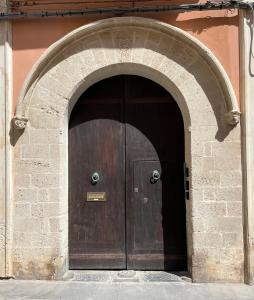 una gran puerta de madera en un arco de un edificio en L’arco di San Giuseppe en Siracusa