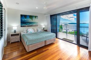 a bedroom with a bed with a view of the ocean at The Panorama 3, Hamilton Island 2 Bedroom 2 Bathroom Ocean View Modern Apartment in Hamilton Island +21 photos