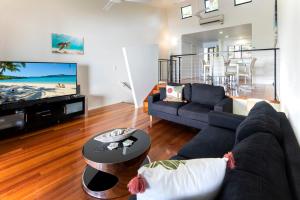 uma sala de estar com um sofá e uma televisão em The Panorama 3, Hamilton Island 2 Bedroom 2 Bathroom Ocean View Modern Apartment em Hamilton Island