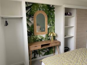 a bedroom with a dressing table and a mirror at Apt Luci Proche Clermont in Beaumont