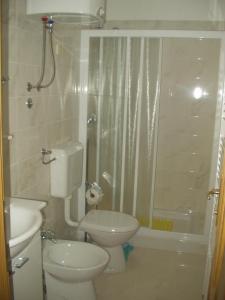 uma casa de banho com um WC, um lavatório e um chuveiro em Apartment Novi Vinodolski em Novi Vinodolski