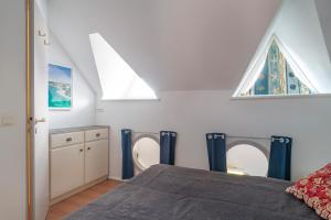 1 dormitorio con 1 cama con cortinas azules y ventana en Plein Sud - Piscine partagée, en Bénodet