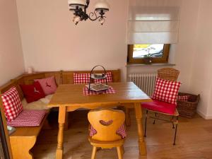 uma sala de jantar com uma mesa de madeira e cadeiras em Idyllische Auszeit am Waldweg em Gmund am Tegernsee