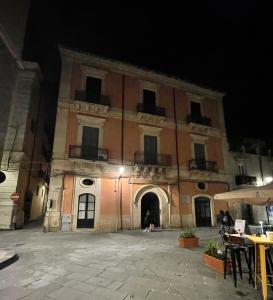 un grande edificio con un cortile di notte di L'arco di San Giuseppe a Siracusa