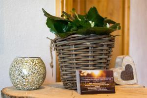 a basket with a plant and a book on a table at Oberreiterhof in Bad Wiessee