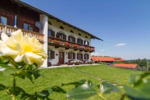 um edifício com uma flor amarela à frente dele em Oberreiterhof em Bad Wiessee