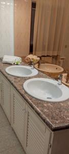 a bathroom counter with two sinks and a mirror at Villa da Rosa in Olbia