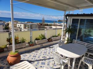 un patio con mesa, sillas y el océano en Terrazza su Serapo, en Gaeta