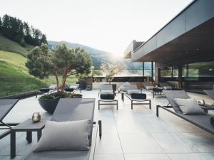 a group of chairs and tables on a patio at Hotel Tirolerhof 4 Sterne Superior in Tux