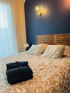 eine Tasche auf einem Bett in der Unterkunft villa bleu marine chic calme et jardin in Andrézieux-Bouthéon