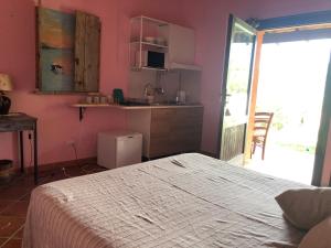 a bedroom with a bed and a table and a kitchen at Amalfatah in Teulada