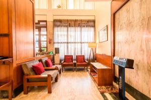 a living room with two chairs and a tv at Bangalore Gate Hotel & Conferences in Bangalore