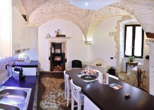 cocina con mesa y chimenea en una habitación en L'Angolo di Gaudì, casa Milà, en Putignano