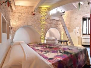łóżko w pokoju z kamienną ścianą w obiekcie L'Angolo di Gaudì, casa Milà w mieście Putignano