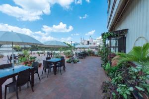 an outdoor patio with tables and chairs and umbrellas at Bangalore Gate Hotel & Conferences in Bangalore