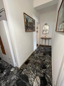 a hallway with a marble floor and a painting on the wall at App di Myrò in Reggio Emilia
