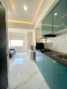 une cuisine avec des armoires bleues et un salon dans l'établissement D10 Modern Apartment 2 Bed Room, à Bandung