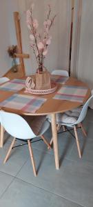 une table et des chaises en bois avec un vase au-dessus dans l'établissement Soleil Couchant de Vanessa et Nicolas, à Mimizan