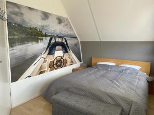 een slaapkamer met een bed en een schilderij van een boot bij Klipper in Terherne