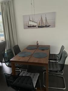 een eettafel met stoelen en een foto van twee boten bij Klipper in Terherne