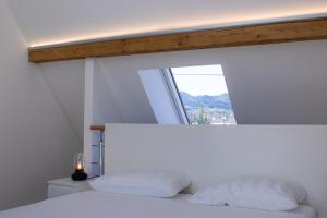 a bedroom with a white bed with a window at Apartment im alten Fronhof in Balingen