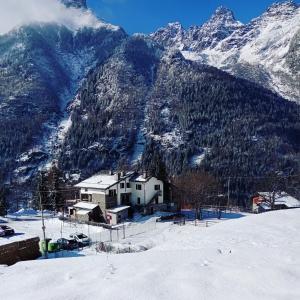 a house in the snow in front of a mountain at Sasso Nero in Chiesa in Valmalenco