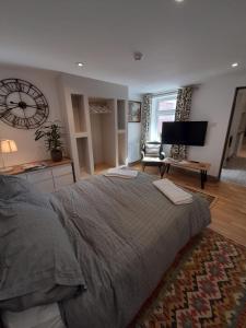 a bedroom with a large bed and a television at cosy quiet apartment in Nottingham