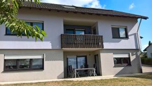 ein Haus mit einem Balkon mit einem Tisch darauf in der Unterkunft Ferienwohnung "Anja" in Fladungen