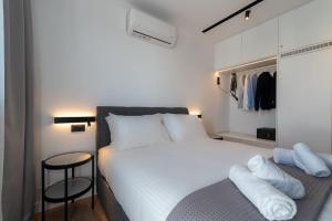 um quarto com uma grande cama branca e um banco em Il Terrazzo in Heraklion em Heraclião