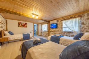 Zimmer mit 3 Betten und einem TV an der Wand in der Unterkunft Villa Nostalji Kalkan Bezirgan'da Havuzlu Villa in Bezirgân + 22 Fotos