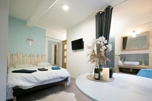 a bedroom with a bed and a bathroom with a sink at L'Oiseau De La Cathédrale - Calme - Jardin - Wifi in Troyes