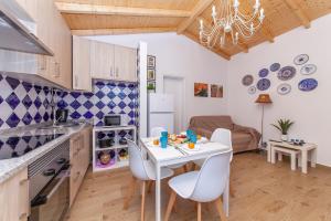 uma cozinha e sala de jantar com uma mesa branca e cadeiras em B54 - Casa Azul in Burgau em Budens