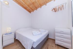 um pequeno quarto com uma cama e uma cómoda em B54 - Casa Azul in Burgau em Budens
