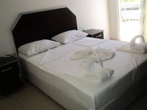 a bed with two swans towels on it at ELSİRA APART in Side