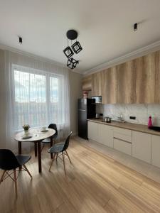 a kitchen with a table and chairs in a room at Апартаменты Soul Park in Astana