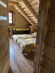 a bedroom in a log cabin with a bed in it at Chata Peťo in Bžany
