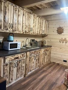 uma cozinha com armários de madeira e um micro-ondas em Chata Peťo em Bžany