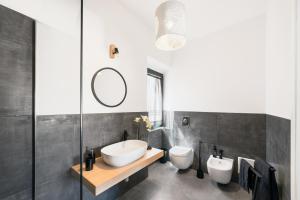 a bathroom with two toilets and a sink and a mirror at La maison del corso in Santa Teresa Gallura