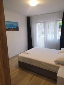 een slaapkamer met een bed en een raam bij Apartments Rodin in Trogir