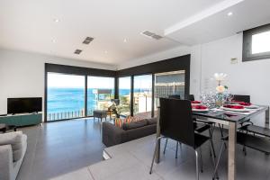 a dining room and living room with a view of the ocean at RNET - Casa 3 - Vista Mar Almadrava Roses in Roses