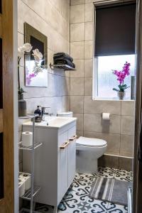 a bathroom with a sink and a toilet and a window at Spacious Liverpool Central Apartment in Liverpool