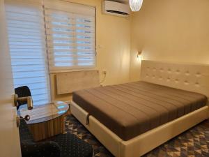 a bedroom with a bed and a table and a window at Apartment Mimi in Herceg-Novi