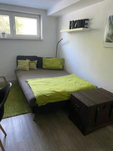 1 dormitorio con 1 cama con manta amarilla y baúl en Ferienwohnung bei Freiburg, en Holzhausen