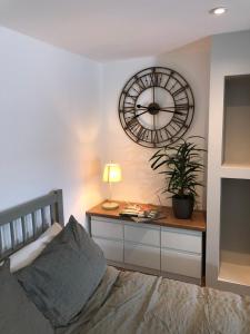 a bedroom with a bed and a clock on the wall at cosy quiet apartment in Nottingham