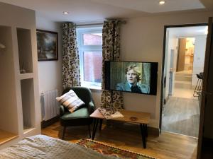 a living room with a flat screen tv on a wall at cosy quiet 1 bedroom apartment Carrington in Nottingham