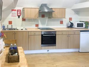 a kitchen with wooden cabinets and a stove top oven at Horseshoe in Saltfleetby Saint Clement